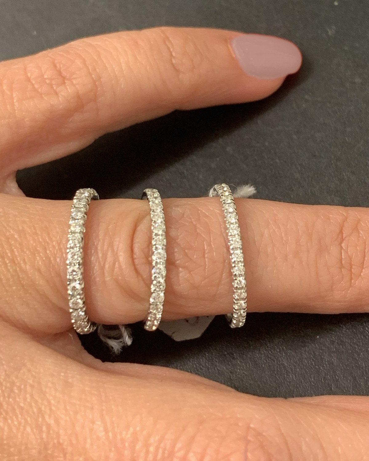 Three pavé diamond eternity bands worn side by side across the fingers