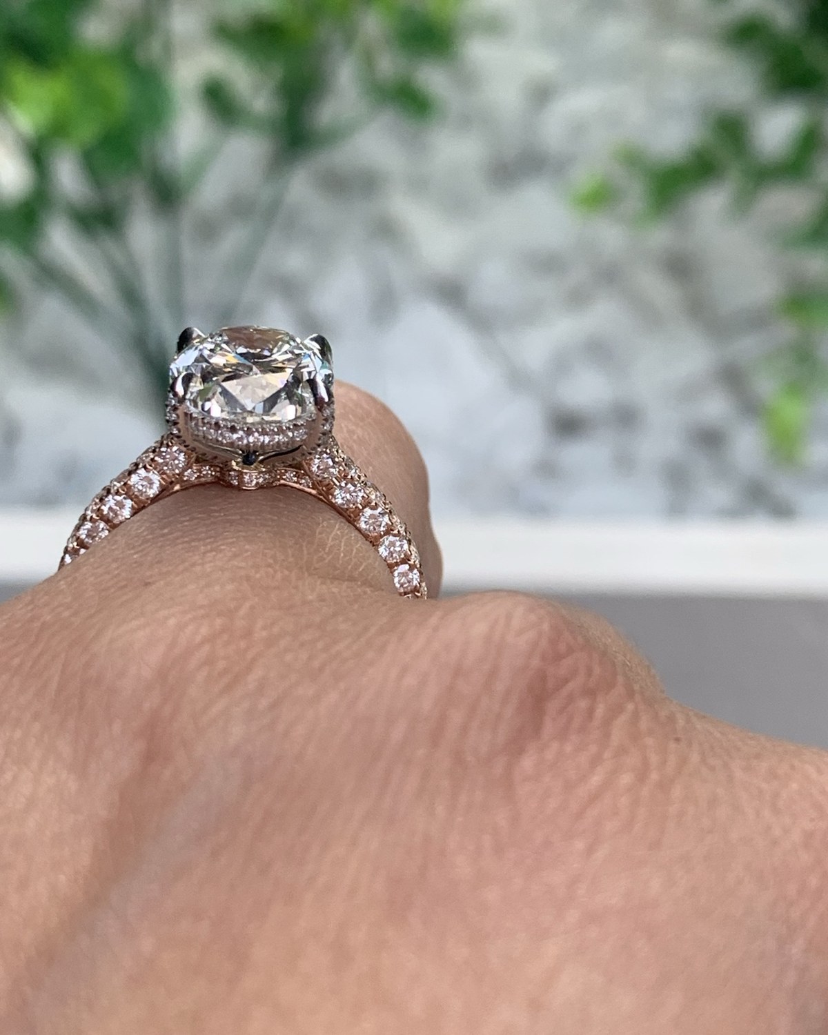 Second profile view of the cushion hidden-halo ring in rose gold, worn on the hand