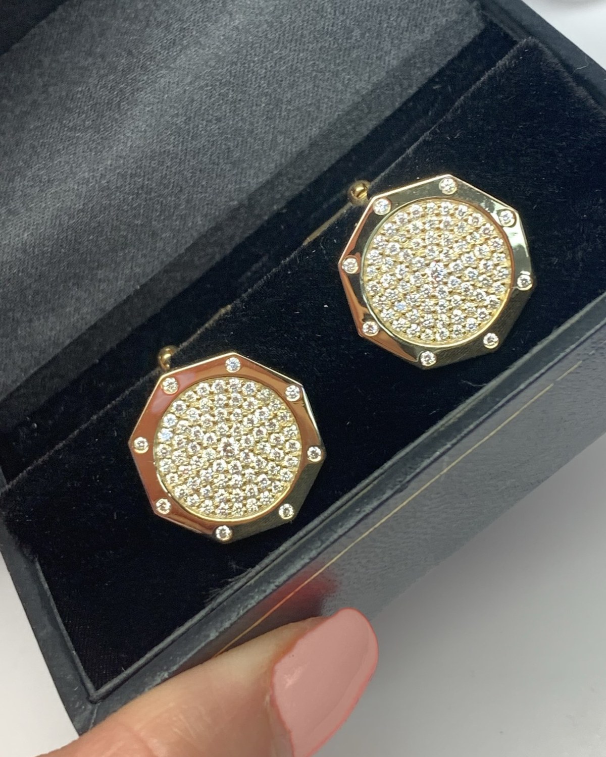 Angled view of the octagonal pavé disc earrings in their presentation box