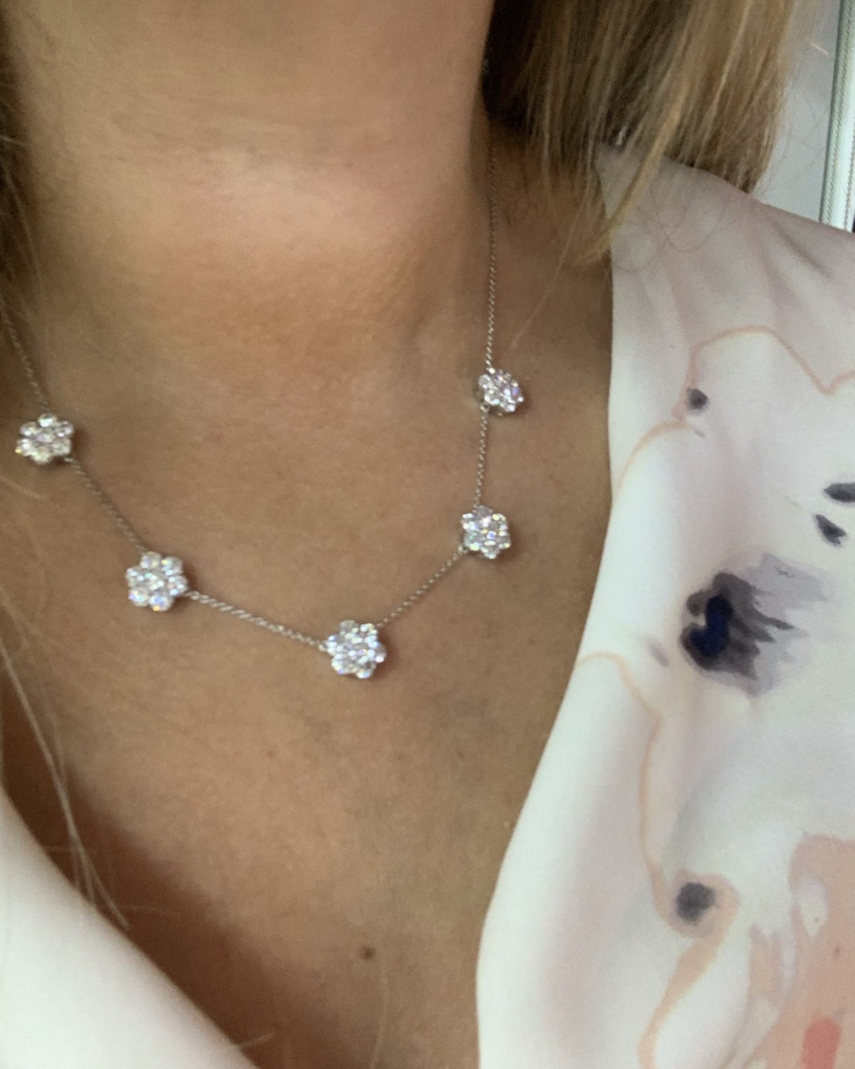 Second view of the diamond flower station necklace worn at the collarbone