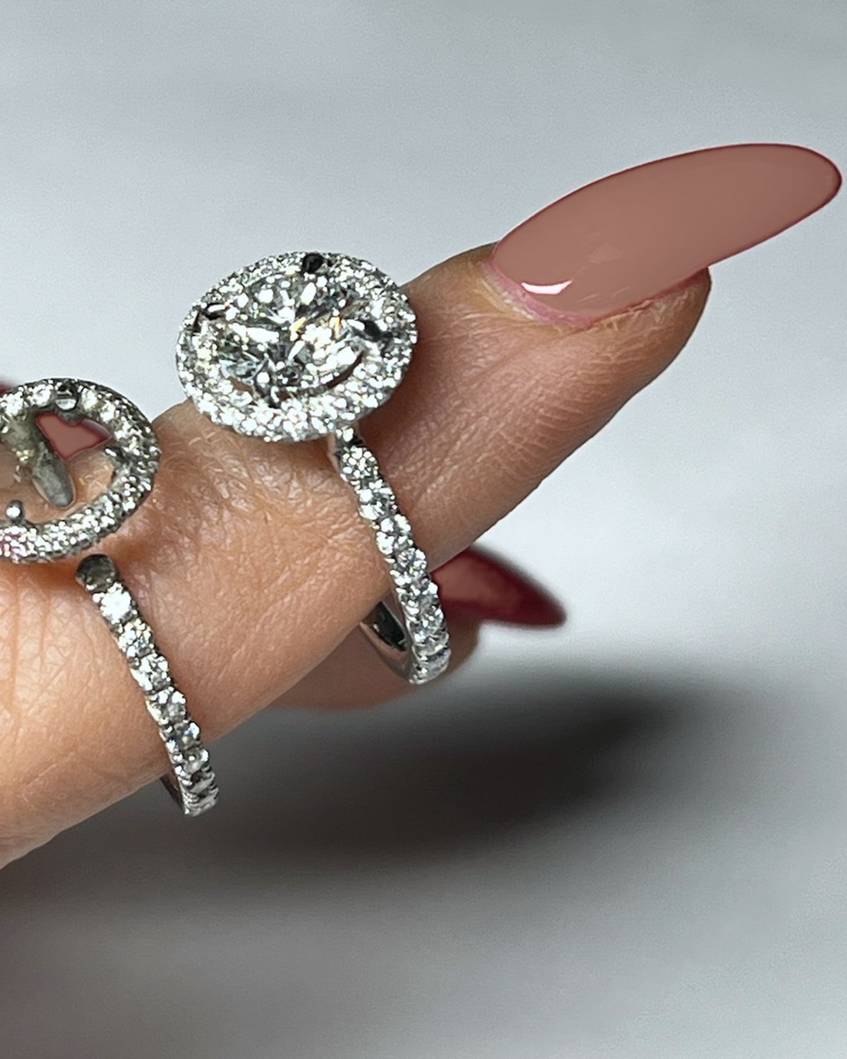 Matched diamond halo engagement ring and wedding band worn together on the hand