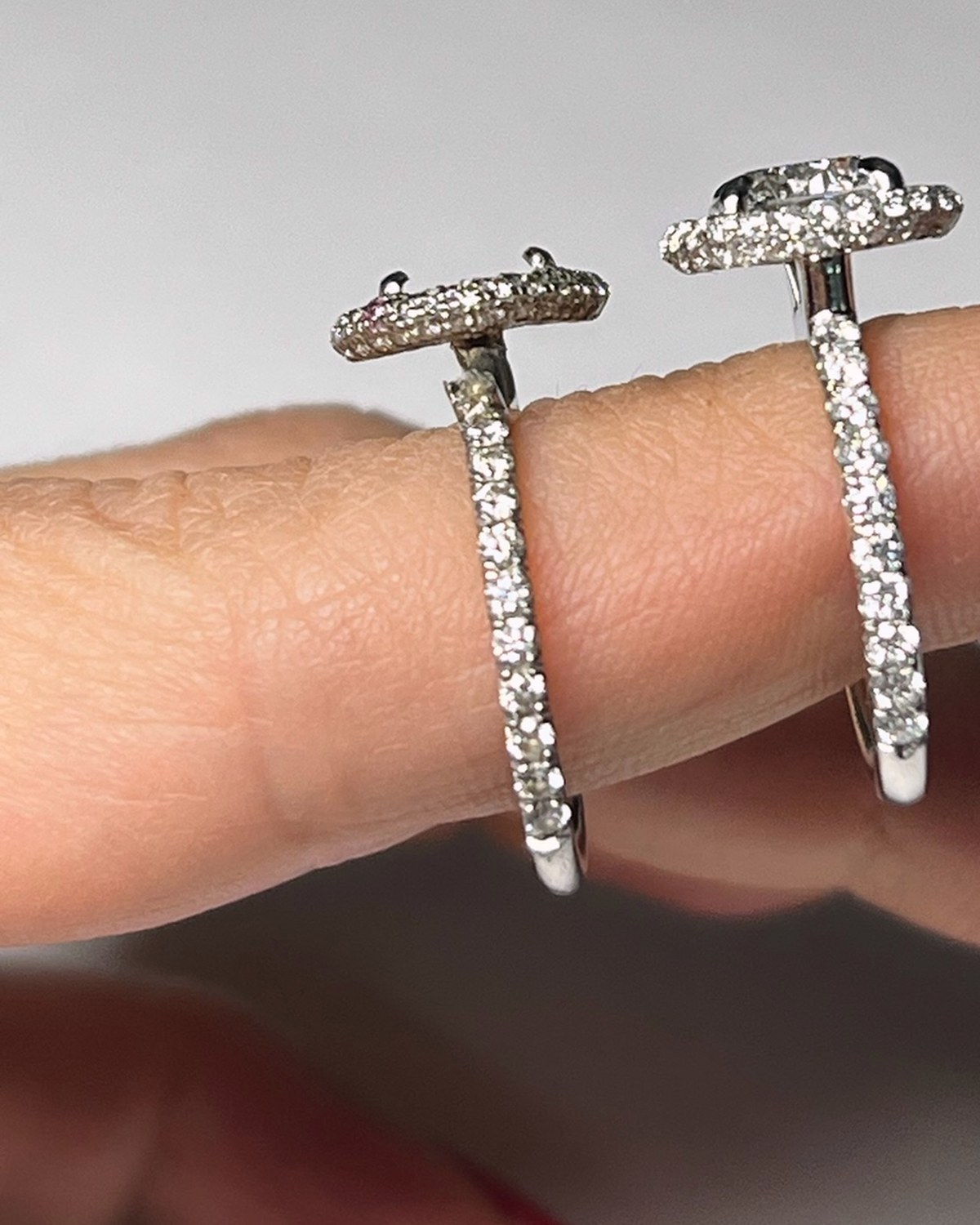 Profile view of the matched halo engagement ring and wedding band worn together, showing the flush fit