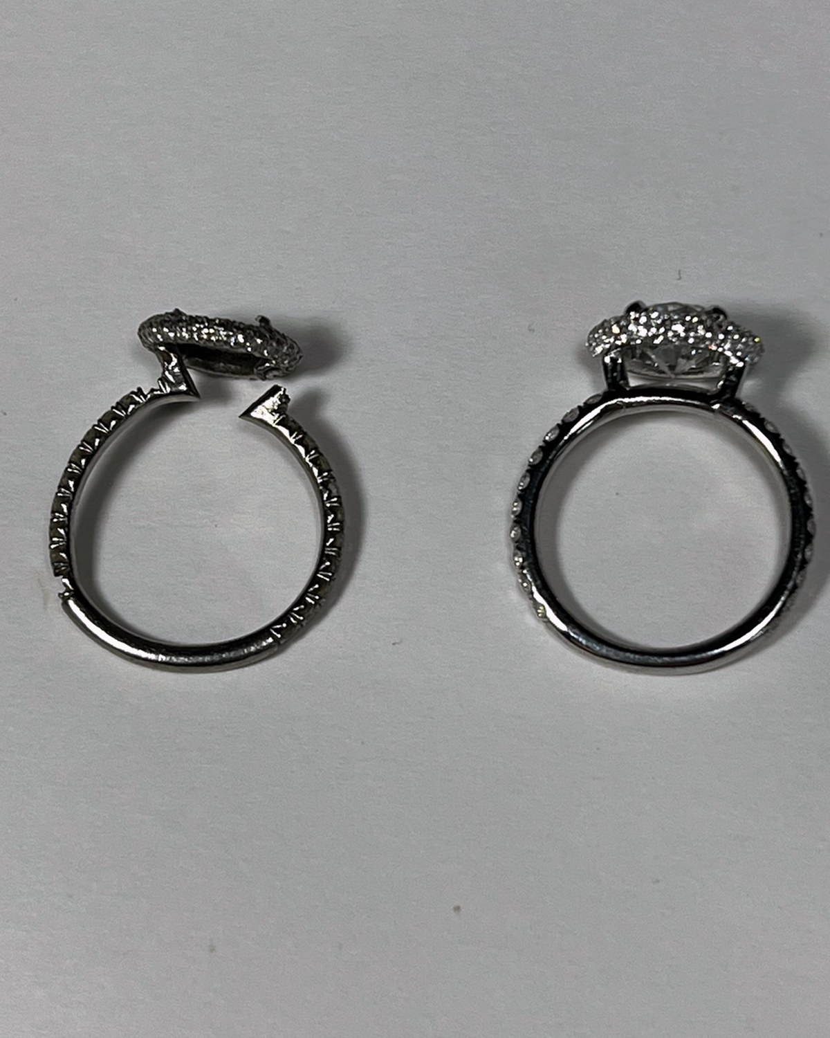 Round diamond halo engagement ring beside its matched contoured wedding band, laid side by side