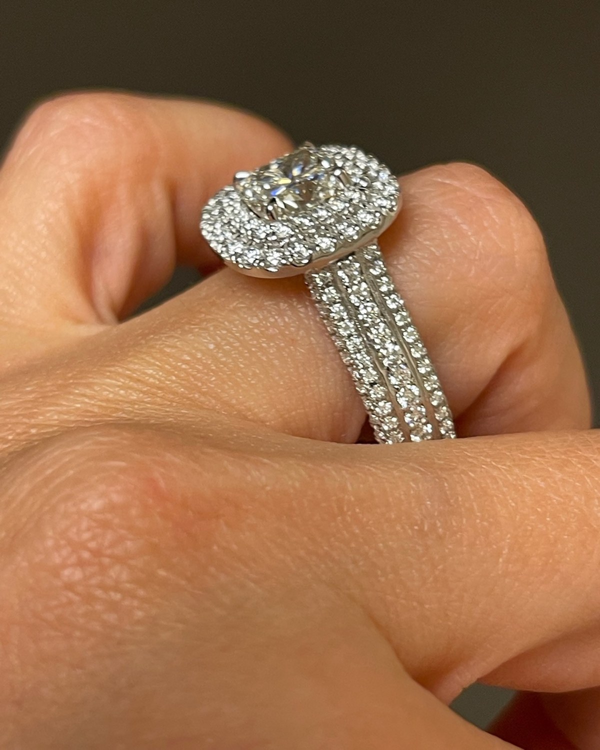 Profile view of a cushion double-halo ring, showing the gallery and the three-row pavé shank
