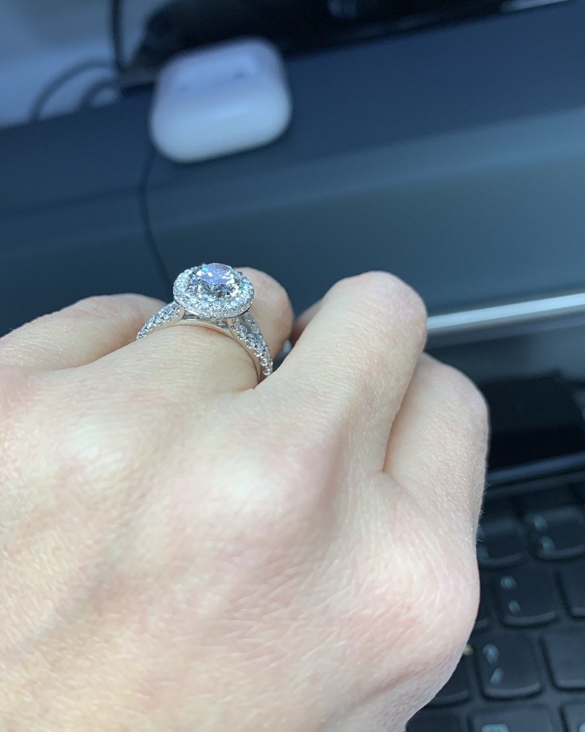 Cushion halo split-shank ring worn on a closed hand