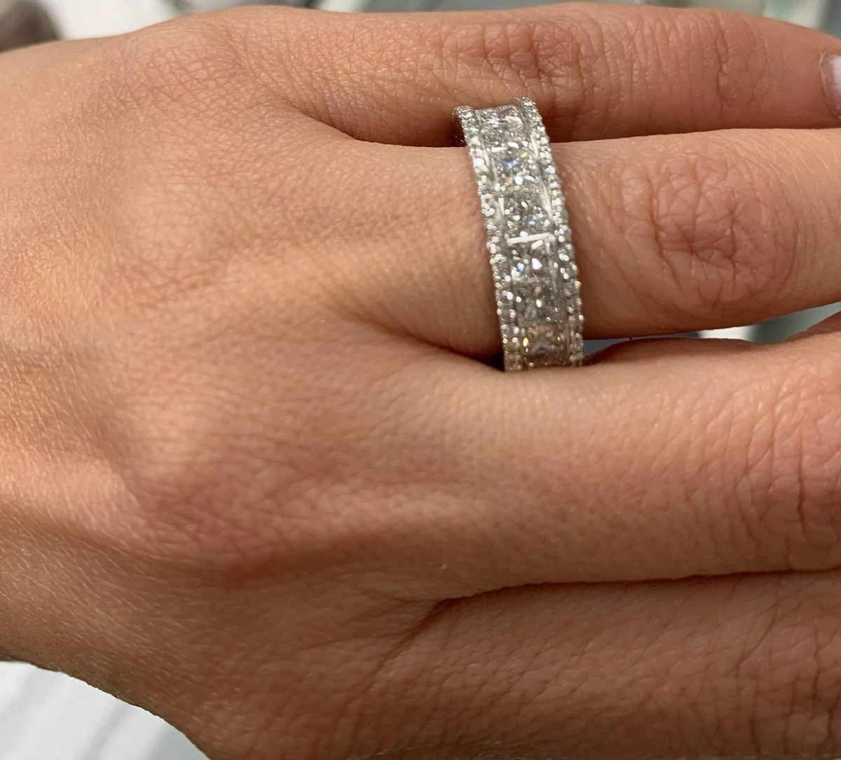 Wide princess-cut diamond band with pavé edges, worn on the hand