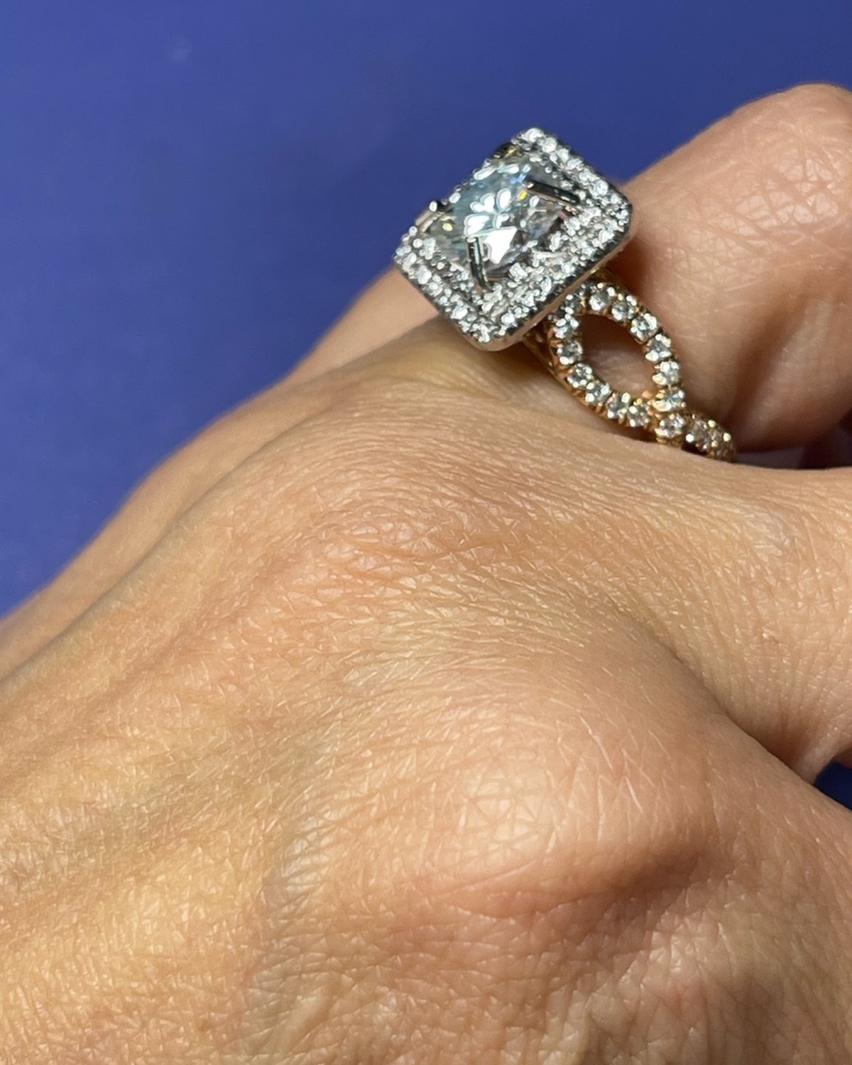 Profile of a princess halo ring on a two-tone rose gold twisted openwork split shank