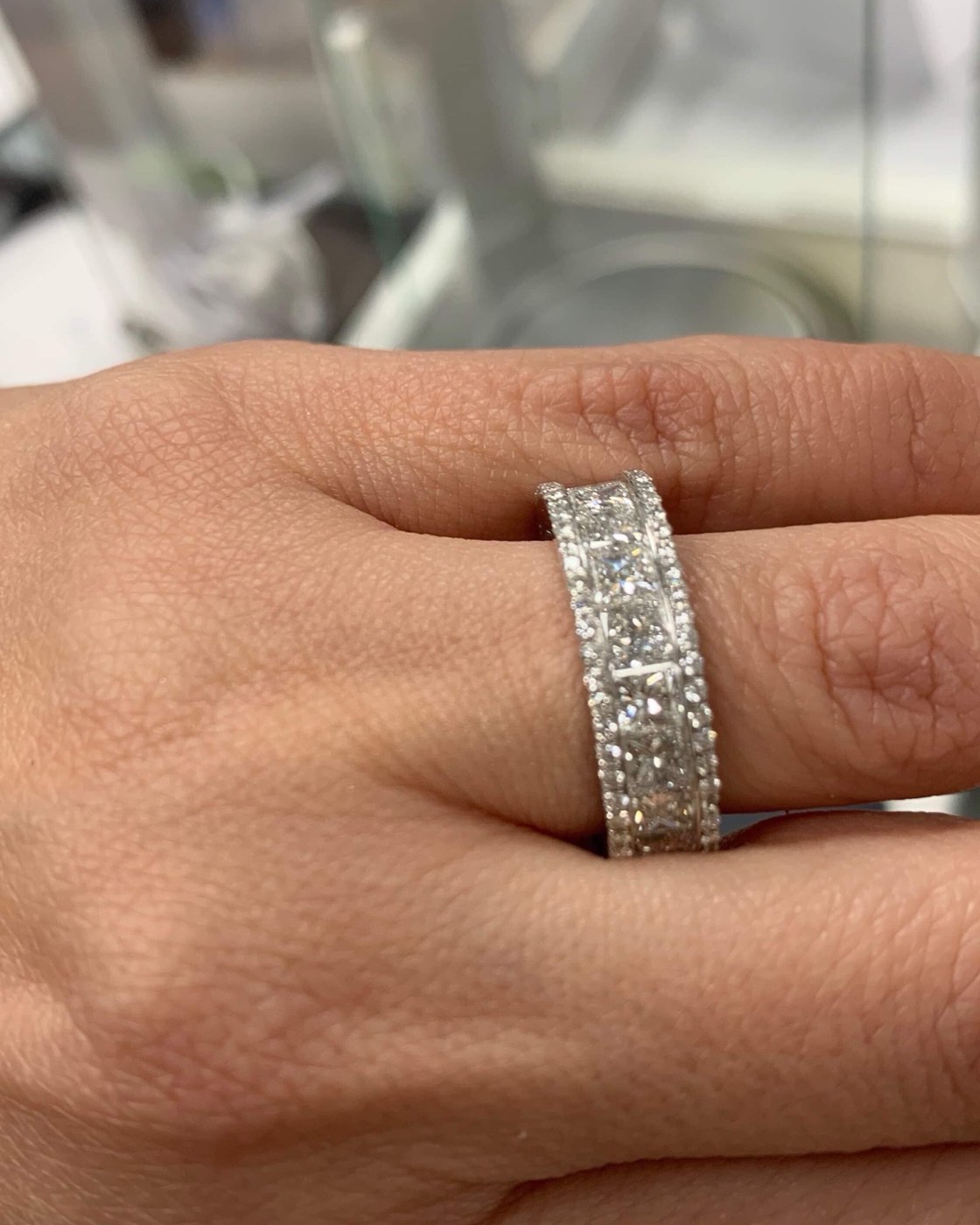 Wide white gold band pavé set across its full width, worn on the finger in profile